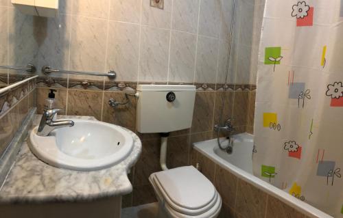 y baño con lavabo, aseo y bañera. en Apartamento Praia de Altura-Terraço BBQ-Wfi-AC, en Altura