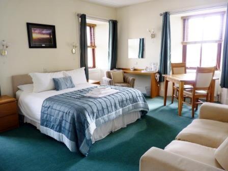 a bedroom with a bed and a table and chairs at Pentland Lodge House in Thurso