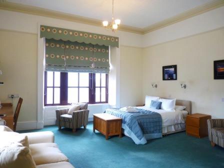 a hotel room with a bed and a couch at Pentland Lodge House in Thurso