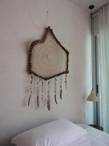 a dream catcher hanging on a wall next to a bed at Villas H2O in Tulum