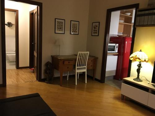 Horto Terapeutico Home في ديسينسانو ديل غاردا: غرفة بها مكتب وكرسي ومطبخ
