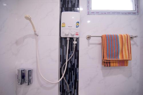 y baño con ducha y manguera. en TN Thanyawit, en Nakhon Ratchasima