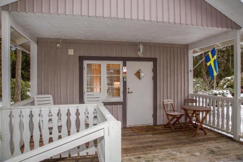 a porch of a house with a flag on it at Comfortable Cottage at Scenic Lake in Landvetter
