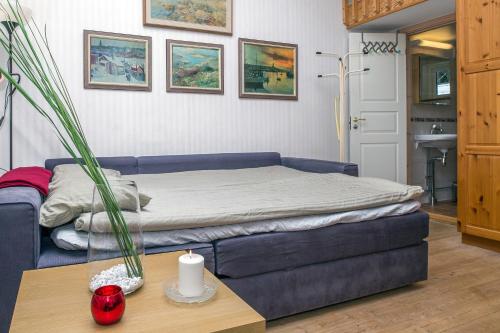 a living room with a bed and a table at Comfortable Cottage at Scenic Lake in Landvetter