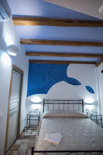 a bedroom with a bed with a blue wall at Coraje Room & Breakfast in Sciacca
