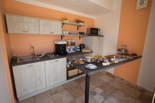 una cucina con un tavolo con del cibo sopra di Coraje Room & Breakfast a Sciacca