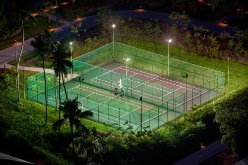a tennis court with several tennis racquets on a sunny day at Kempinski Seychelles Resort in Baie Lazare Mahé