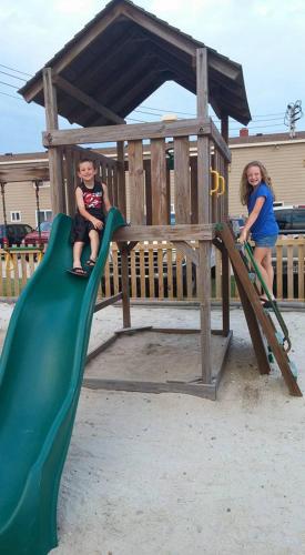 a boy and a girl playing on a playground at Outer Banks Motor Lodge in Kill Devil Hills
