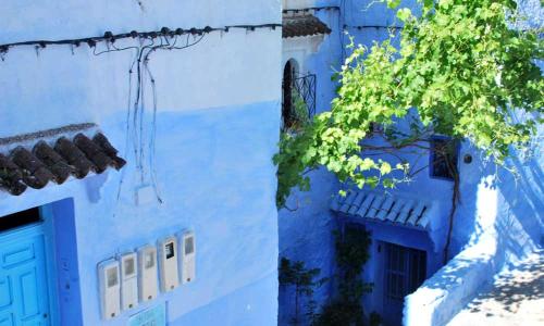 two pictures of a blue building with a door at Dar Antonio in Chefchaouene