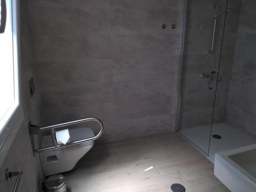a bathroom with a shower and a toilet and a sink at Punta Carnero Hostal in Algeciras