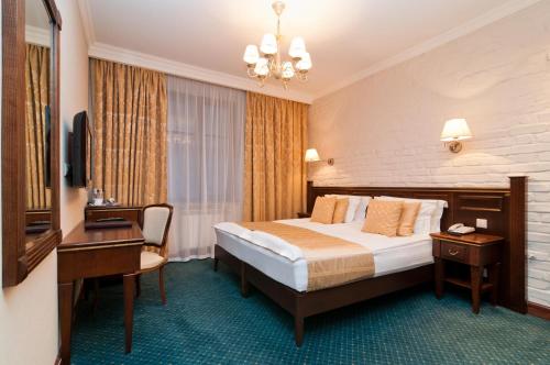 a hotel room with a bed and a desk at Tradition Hotel in Saint Petersburg