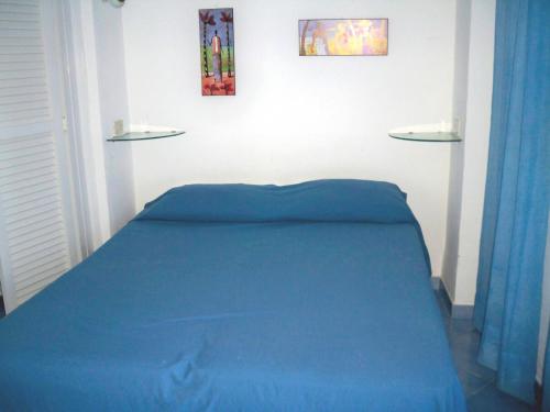 a bedroom with a blue bed and two pictures on the wall at L'Isolana Case Vacanza Palma 1 in Ponza