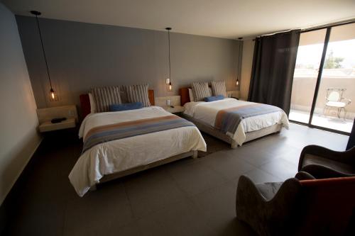 a hotel room with two beds and a window at Hotel Helverica in San Cristóbal de Las Casas
