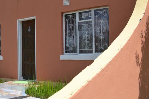 a building with a window and some grass at Seelo Guest Accommodation in Letlhakawe
