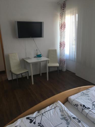 a room with a table and a tv and a bed at Pension "Am Markt" in Treis-Karden
