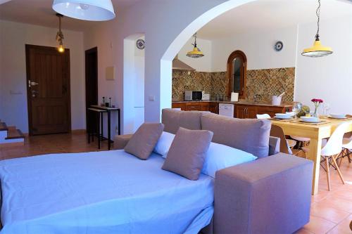 a living room with a blue bed and a kitchen at M&M House in Cala Romàntica