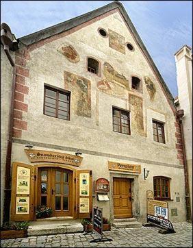 a large stone building with windows and doors at Hotel Svambersky dum in Český Krumlov