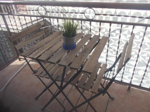 a wooden bench with a potted plant on a balcony at Traditional Guest house Chrisyis in Pyrgi