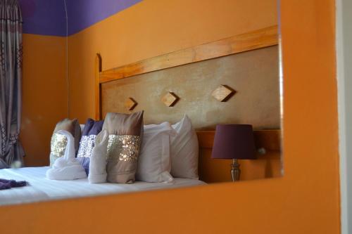 a bedroom with a bed with pillows and a mirror at Seelo Guest Accommodation in Letlhakawe