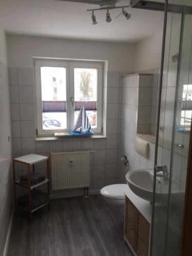 een badkamer met een wastafel, een toilet en een raam bij Seepferdchen in Stralsund