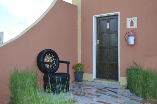 a house with a chair next to a door at Seelo Guest Accommodation in Letlhakawe