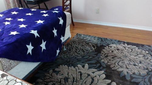 a room with a bed with an american flag pillow and a rug at HB Guest Home 5 in Waterloo