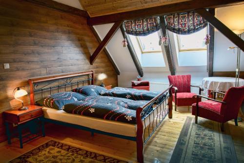 1 dormitorio con 1 cama, 2 sillas y mesa en Penzión u Maroša, en Kežmarok