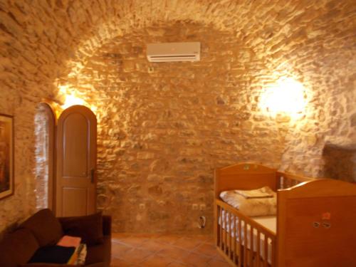 a room with a bed in a stone wall at Traditional Guest house Chrisyis in Pyrgi