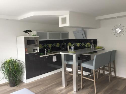 Apartment Ferienwohnung في Sulzbach: مطبخ مع كونتر أسود وطاولة وكراسي
