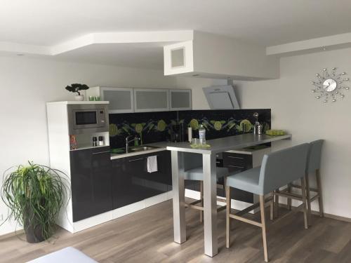 cocina con encimera negra, mesa y sillas en Apartment Ferienwohnung, en Sulzbach