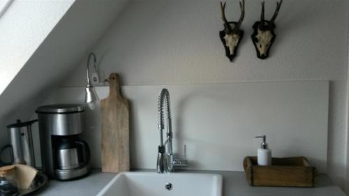 a kitchen counter top with a sink and a utensils at Charmante, moderne Wohnung in Greven