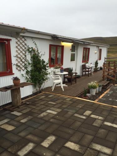 a house with a wooden deck with a table and chairs at Seljaland ferðaþjónusta in Búðardalur