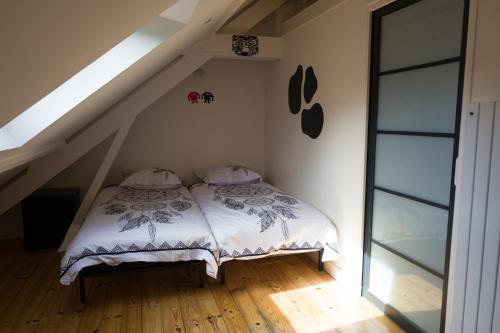 - une chambre avec un lit dans l'angle du grenier dans l'établissement Le 22, à Honfleur