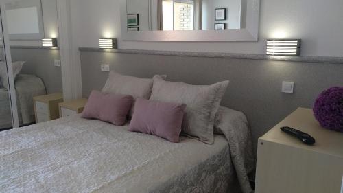 ベナルマデナにあるApartamentos Aguila Minervaのベッドルーム1室(紫色の枕2つ付きのベッド1台付)