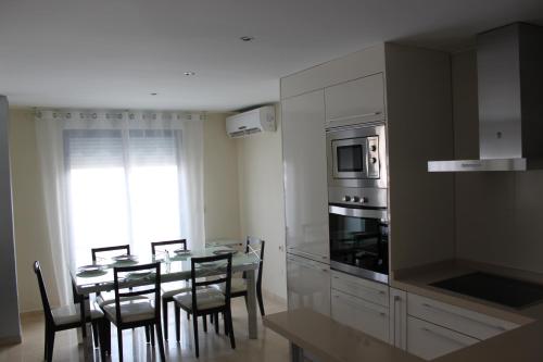 Playa de GandiaにあるApartamento El Eden Playa de Gandíaのキッチン(テーブル、椅子、電子レンジ付)