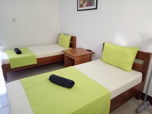 a room with two beds with green and white sheets at Ahras Place in Coron