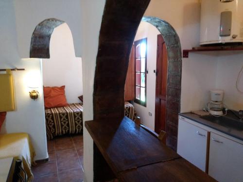 a kitchen with an archway and a room with a bed at El Alto de las Paredes in San Rafael