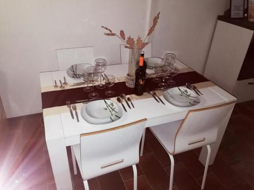 a white table with glasses and a bottle of wine at Casa Elia in Venice