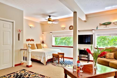 a bedroom with a bed and a living room at Orchid Tree B&B in Hilo