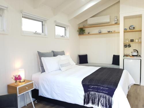 a bedroom with a large white bed and two windows at Alkira in Leongatha