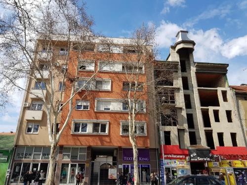 a building on a city street with trees in front at Apartment GEA 18 in Novi Sad