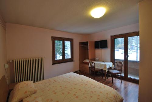 ein Hotelzimmer mit einem Bett und einem Tisch mit einem Tisch in der Unterkunft Hotel Ristorante Baldi in Fiesso