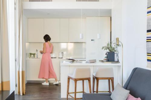 a woman in a pink dress standing in a kitchen at The Lumiares Hotel & Spa - Small Luxury Hotels Of The World in Lisbon