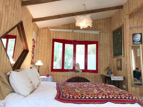 ein Schlafzimmer mit Holzwänden und ein Bett in einem Zimmer in der Unterkunft Maipo Shanti Lodge in San José de Maipo