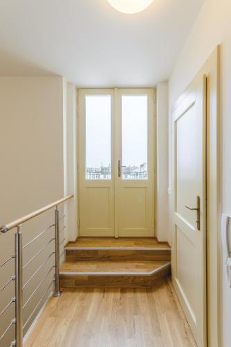 a hallway with a yellow door and two windows at Riverside SPIRIT in Prague