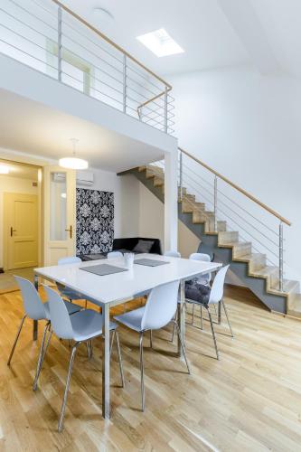 a dining room with a white table and chairs at Riverside SPIRIT in Prague