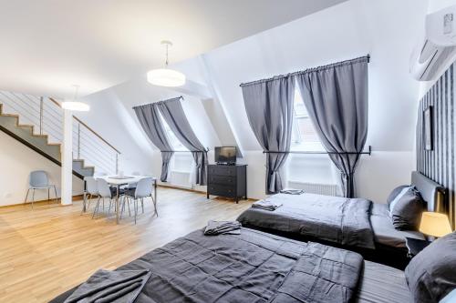 a bedroom with two beds and a table with chairs at Riverside SPIRIT in Prague