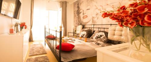 アデへにあるFantastic Apartment Marilyn Orlando 85のベッドルーム1室(ベッド1台、花瓶1本付)