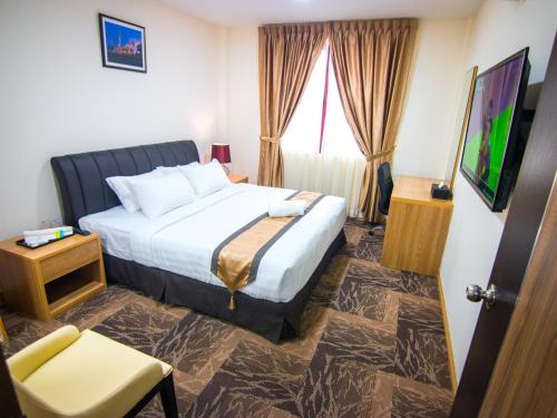a hotel room with a bed and a tv at Al Afiah Hotel in Bandar Seri Begawan