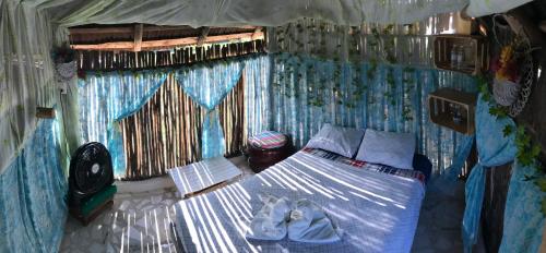 a small bedroom with a bed in a room at Ecocamping Yaxche in Bacalar
